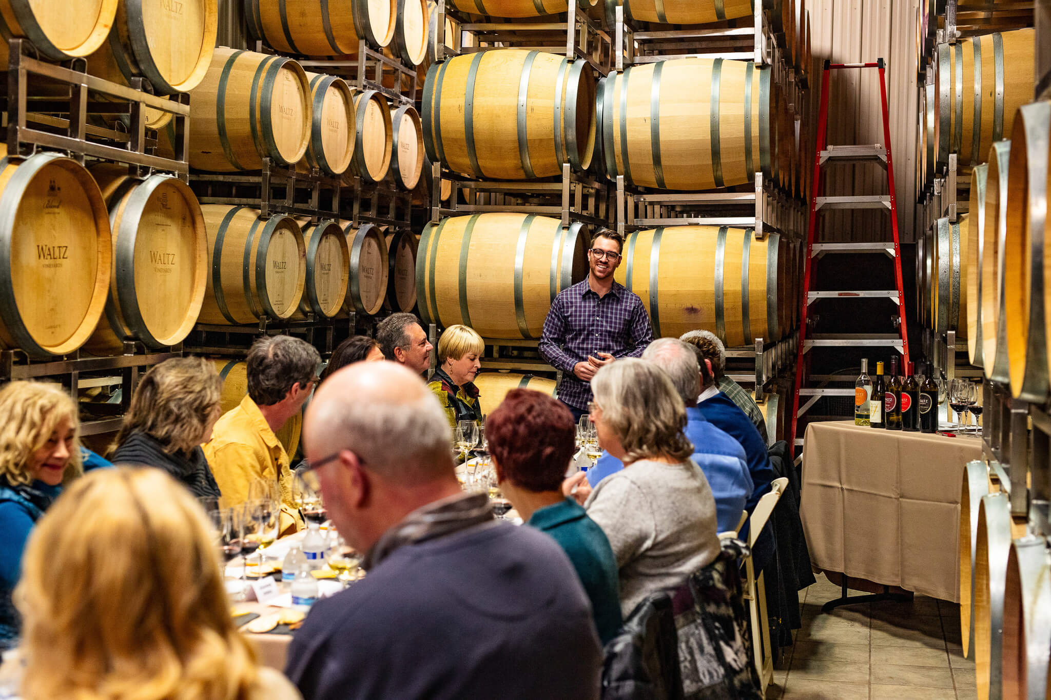 Zach Waltz with wine club members in barrel room